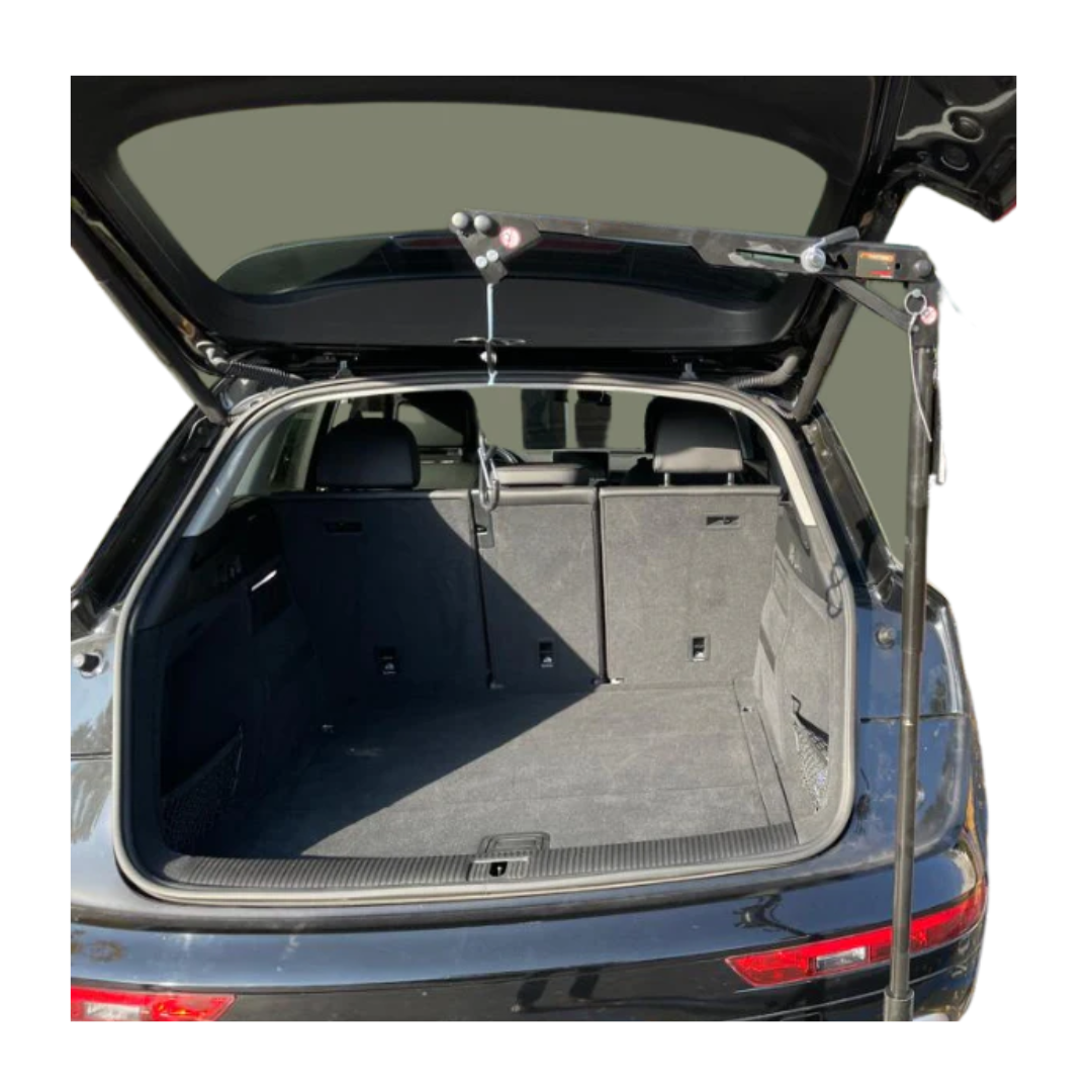Open trunk of a black SUV with a FreeRider Scooter Lift For Vehicles, a portable mobility lift for loading and unloading heavy items, conveniently mounted at the edge of the trunk opening.